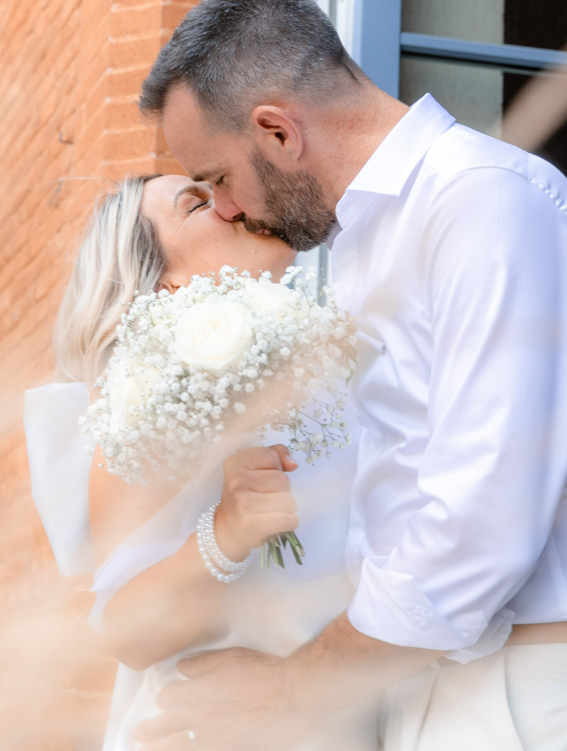 Photographie de mariage romantique : couple de mariés s'enlaçant lors d'une séance portrait en extérieur par Auxie Boivin.
